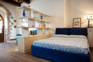 sypialnia z niebieskim łóżkiem i drewnianymi półkami w obiekcie Camere Capobove Assisi w Asyżu