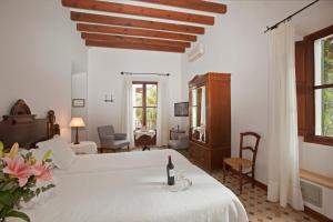 Turismo de Interior S'Ardeviu في سولير: غرفة نوم مع سرير مع زجاجة من النبيذ عليه