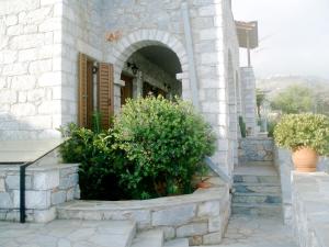 uma entrada para um edifício com um arco e plantas em VRAHOS - o ΒΡΑΧΟΣ em Ágios Nikolaos