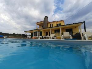 a villa with a swimming pool in front of a house at Eagle House in Sao Pedro de Tomar