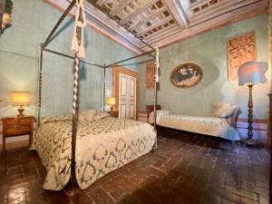 1 dormitorio con cama con dosel y sofá en VesConte Residenza D'epoca dal 1533 en Bolsena
