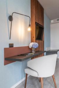 a desk in a room with a white chair at Hotel Verde Mar & SPA in Ribeira Grande