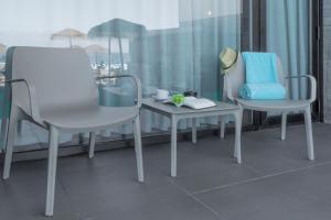 two chairs and a table in front of a window at Hotel Verde Mar & SPA in Ribeira Grande