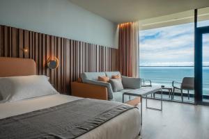 a bedroom with a bed and a view of the ocean at Hotel Verde Mar & SPA in Ribeira Grande