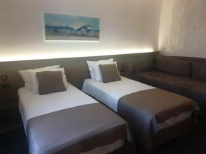 兹拉蒂博尔Standardna soba Zlatibor centar 205的一张沙发的酒店客房内的两张床
