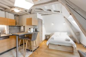 eine Küche und ein Schlafzimmer mit einem Bett und einem Schreibtisch in der Unterkunft Résidence de Tourisme Central Parc Tours in Tours
