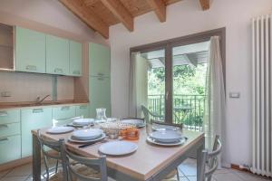 cocina con mesa, sillas y ventana en Appartamento al Bosc Grauno Ospitar, en Grauno