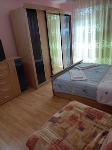 a bedroom with a bed and a dresser and windows at Apartments and Rooms Mila in Ulcinj
