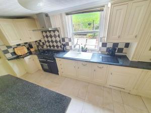 a kitchen with white cabinets and a sink and a window at Spectacular Period Property Located In Leicester in Leicester