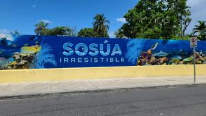 a blue wall with a sign that reads siesta irresistible at Europa Hotel and Condo in Sosúa
