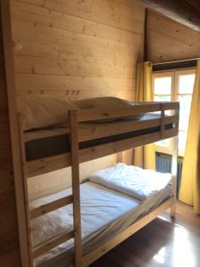 a bedroom with two bunk beds in a log cabin at Chalet Tire-corde in Praz-sur-Arly