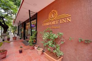 FabHotel S Comfort Inn في بانغالور: واجهة متجر فيه نباتات الفخار خارجه