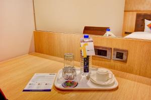 a tray with a bottle of water and a plate of food at FabHotel S Comfort Inn in Bangalore