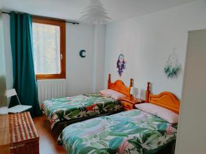 Un dormitorio con dos camas y una ventana. en Apartamento Diezcapanas, en Villanúa