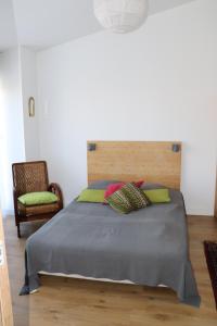 ein Schlafzimmer mit einem großen Bett und einem Stuhl in der Unterkunft CHAMBRES chez l'habitant Córdoba et Lhassa in Bordeaux