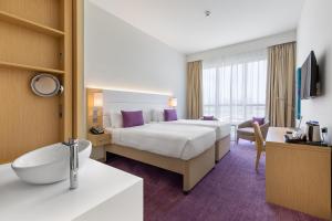 a hotel room with a bed and a bathroom at Premier Inn Dubai Ibn Battuta Mall in Dubai +47 photos