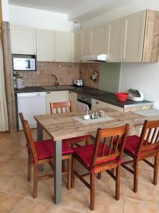 cocina con mesa de madera y 4 sillas en Apartmán u Vlka en Donovaly