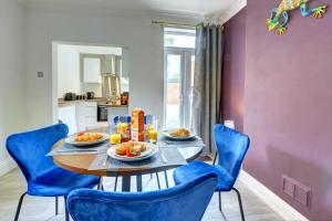 a dining room with a table and blue chairs at The Quirky Cottage in Leicester +13 photos