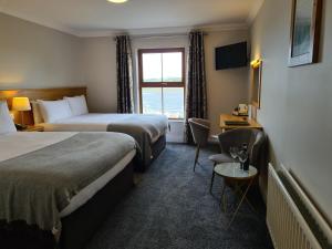 a hotel room with two beds and a window at Caisleain Oir Hotel in Annagry