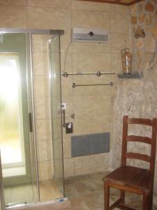 eine Dusche mit Glastür und einem Holzstuhl in der Unterkunft Dipendanza Veneri in Salve