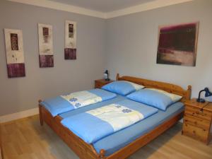 sypialnia z 2 łóżkami i niebieskimi poduszkami w obiekcie Ferienwohnungen Kremsbrucker w mieście Klagenfurt
