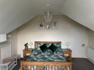 a bedroom with a bed with green pillows at Danbury Lodge Penthouse in Matlock