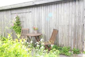 2 Stühle und ein Tisch im Garten in der Unterkunft Ferienwohnung Rosenkate in Sankt Peter-Ording