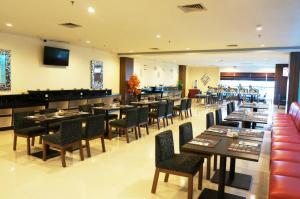 un ristorante con tavoli e sedie e un bar di Ameera Hotel a Pekanbaru