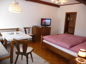 1 dormitorio con cama, mesa y TV en Haus Gradwohl, en Schladming