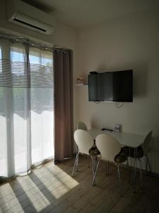 uma sala de jantar com uma mesa e cadeiras e uma televisão em Appartma Katja em Gabrovica pri Črnem Kalu