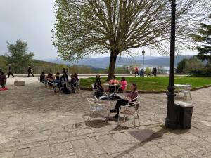 Hotel Monasterio de Leyre في Yesa: مجموعة من الناس يجلسون على الكراسي في الحديقة