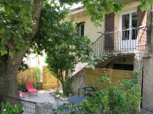 un patio con 2 sillas rojas y un balcón en Location& gîtes, en Sarrians