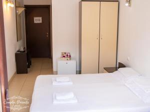 コスティネシュティにあるVila Poienitaのベッドルーム1室(白いベッド1台、白いタオル2枚付)