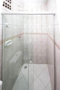 a shower with a glass door in a bathroom at Pousada Santa Fé in Porto De Galinhas