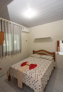 a bedroom with a bed with a bow on it at Pousada Santa Fé in Porto De Galinhas