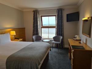 a hotel room with a bed and a window at Caisleain Oir Hotel in Annagry