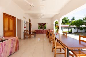 a dining room with a long table and chairs at Casadani Luxury Apartment in Grand Anse