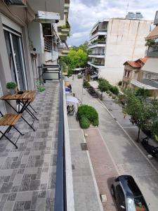 a balcony with tables and chairs and a car on a street at Trikala Easy Living B1 kai B2 in Tríkala