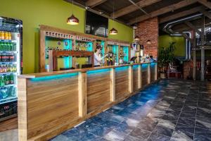eine Bar in einem Restaurant mit einer Frau hinter der Theke in der Unterkunft Timėjas in Ringaudai
