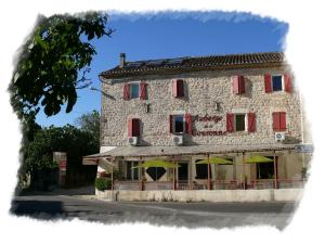 a large stone building with umbrellas in front of it at Auberge de la Couronne in Lablachère