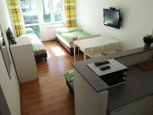 una pequeña sala de estar con mesa y sofá en Apartamenty Asia Kraków, en Cracovia