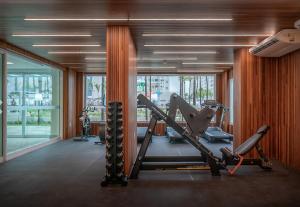 um ginásio com equipamento cardiovascular numa sala com janelas em Salinas Exclusive Resort em Salinópolis