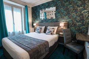 um quarto de hotel com uma cama e uma cadeira em Hotel De La TA em Rennes