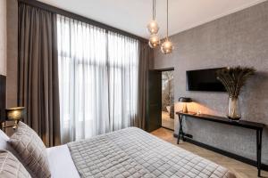 a bedroom with a bed and a large window at Cavallaro Hotel in Haarlem