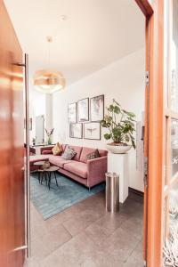 ein Wohnzimmer mit einem rosa Sofa und einem Tisch in der Unterkunft Fabelhafte Wohnungen in der Altstadt in Heidelberg