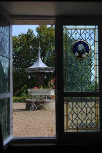 a view of a garden through a window with a fountain at Suite au château - Domaine de la Gavolerie in Bessé-sur-Braye