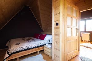 een slaapkamer met een bed in een houten hut bij Prestige Apartamenty Pod Blachówką in Kościelisko