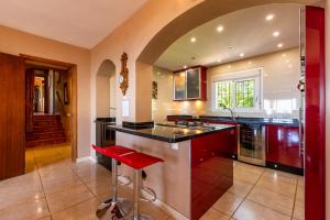 a kitchen with a counter and a red stool at Villa Magica Andalucian charm in Benalmádena