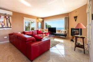 a living room with a red couch and a fireplace at Villa Magica Andalucian charm in Benalmádena