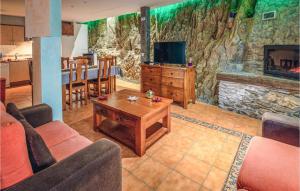 sala de estar con sofá, mesa y chimenea en Lovely Apartment In La Omauela With Kitchen, en La Omañuela